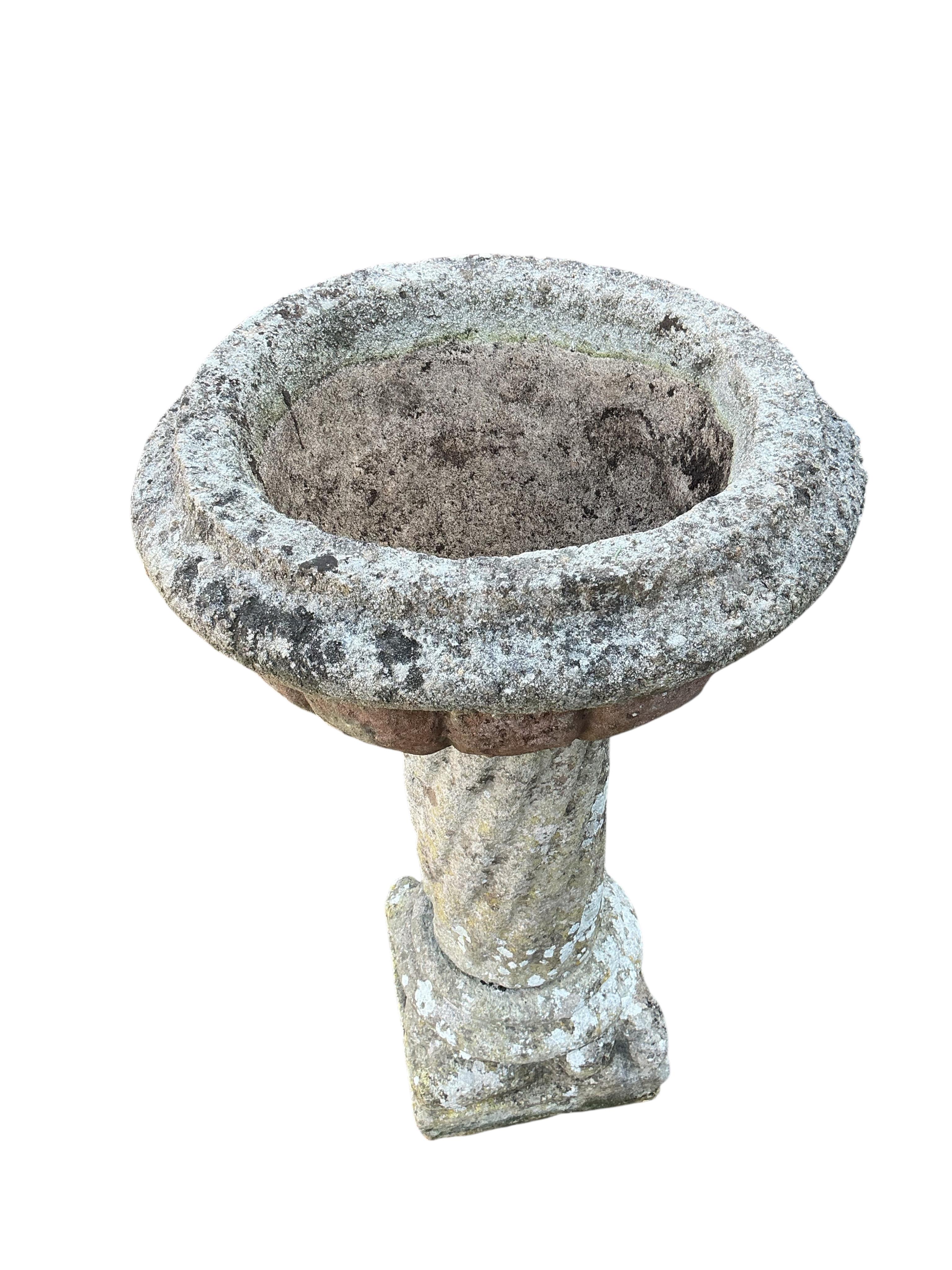 A reconstituted stone garden planter, diameter 54cm, height 90cm